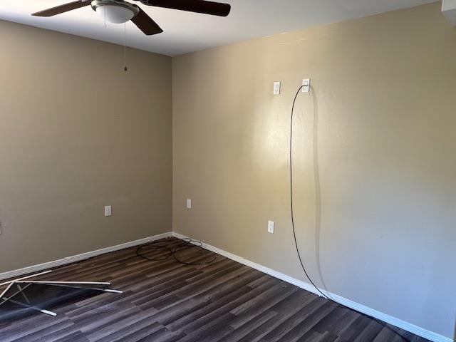 empty room with ceiling fan and dark hardwood / wood-style floors