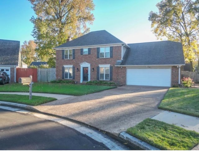 colonial inspired home with a front yard and a garage