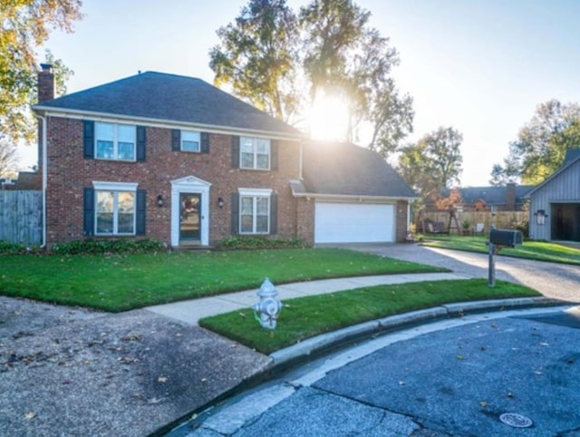 colonial home with a front lawn and a garage