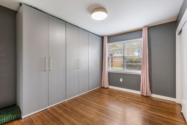 unfurnished bedroom featuring hardwood / wood-style flooring and a closet