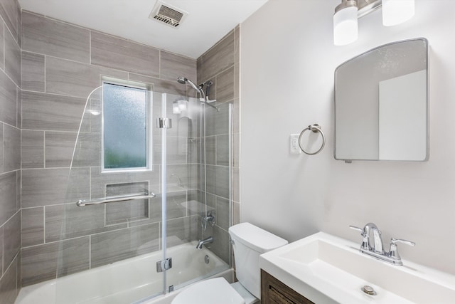 full bathroom featuring shower / bath combination with glass door, vanity, and toilet