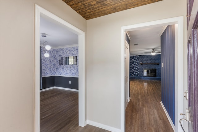 hallway with wood-type flooring, crown molding, and wood ceiling