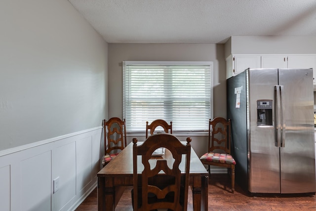 dining room with dark hardwood / wood-style floors and a textured ceiling