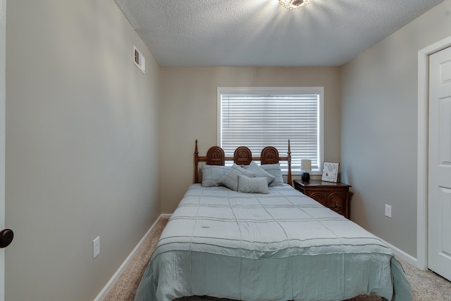 bedroom featuring a textured ceiling and carpet floors