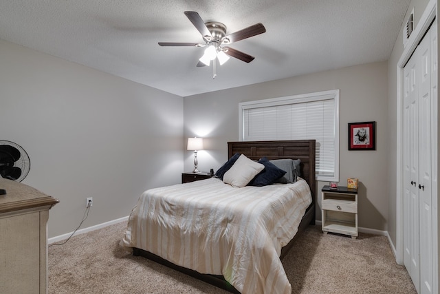 carpeted bedroom with ceiling fan, a textured ceiling, and a closet