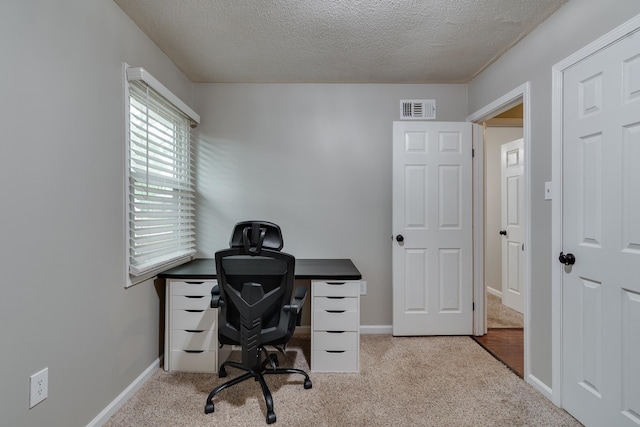 home office featuring light carpet and a textured ceiling