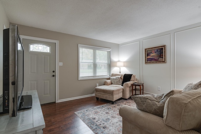 living room with dark hardwood / wood-style flooring and a textured ceiling