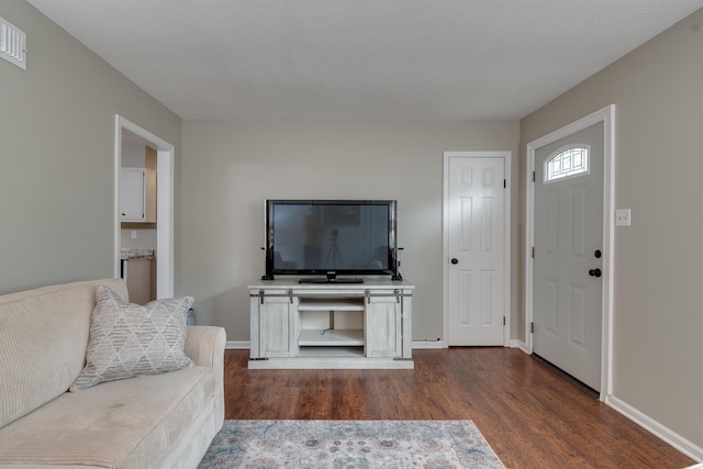 living room featuring a textured ceiling and dark wood-type flooring