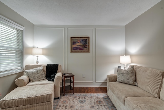 living room featuring a textured ceiling and light wood-type flooring