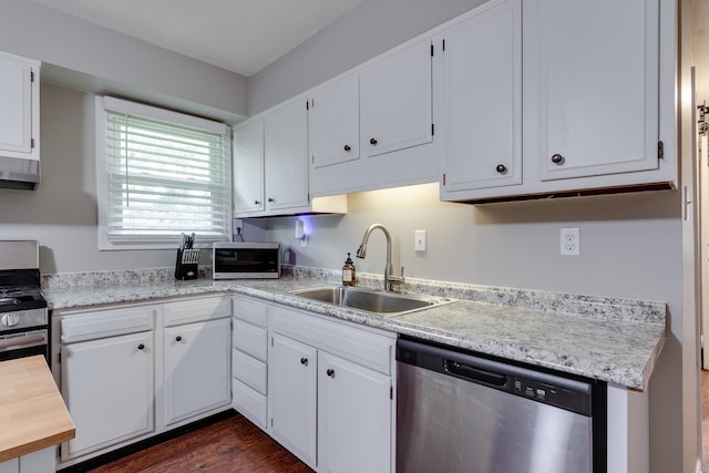 kitchen with white cabinets, sink, dark hardwood / wood-style floors, appliances with stainless steel finishes, and extractor fan