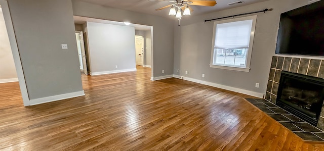 unfurnished living room with a fireplace, hardwood / wood-style flooring, and ceiling fan