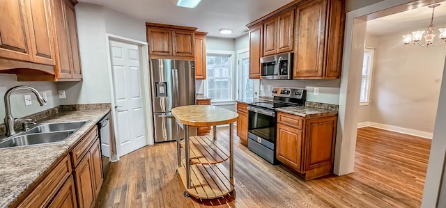 kitchen featuring hardwood / wood-style flooring, a healthy amount of sunlight, sink, and appliances with stainless steel finishes