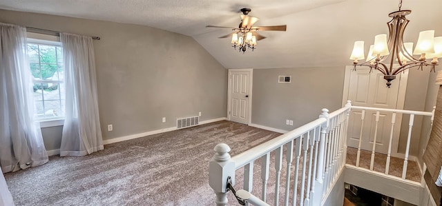 interior space featuring a textured ceiling, carpet, a chandelier, and lofted ceiling