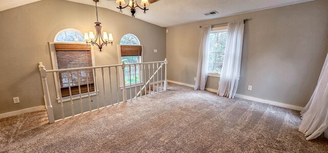 unfurnished room featuring carpet, a chandelier, a textured ceiling, and vaulted ceiling