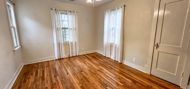 empty room with hardwood / wood-style floors and ceiling fan