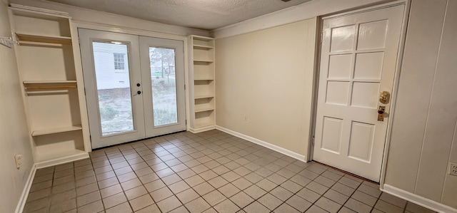 entryway featuring tile patterned floors, french doors, and a textured ceiling