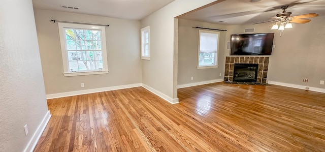 unfurnished living room featuring a fireplace, hardwood / wood-style flooring, and ceiling fan