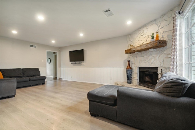 living room with a fireplace and light wood-type flooring