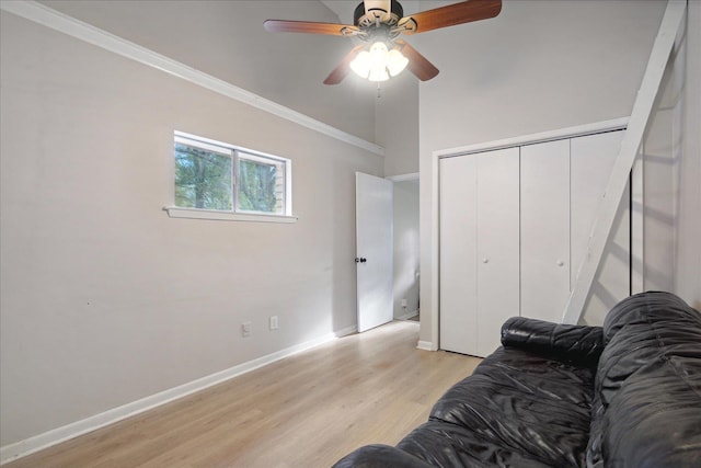 living room featuring light wood-type flooring, ceiling fan, and ornamental molding