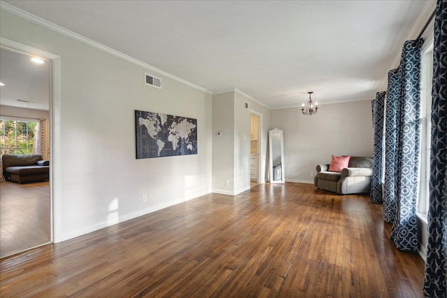 spare room with dark hardwood / wood-style floors, ornamental molding, and a notable chandelier