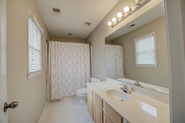 bathroom with vanity, a healthy amount of sunlight, and toilet