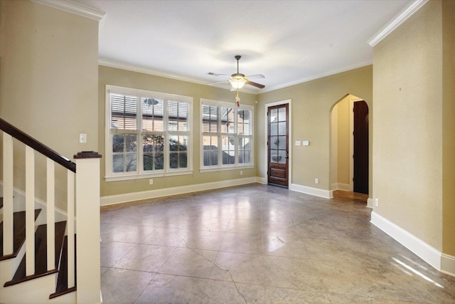 empty room with crown molding, plenty of natural light, and ceiling fan