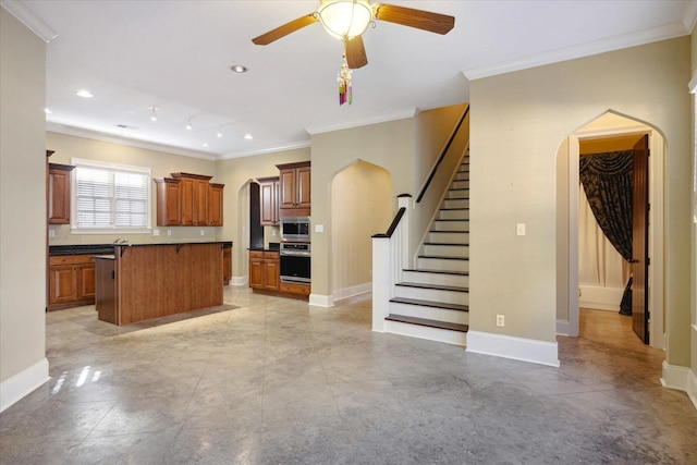 kitchen featuring a center island, stainless steel appliances, ceiling fan, and ornamental molding