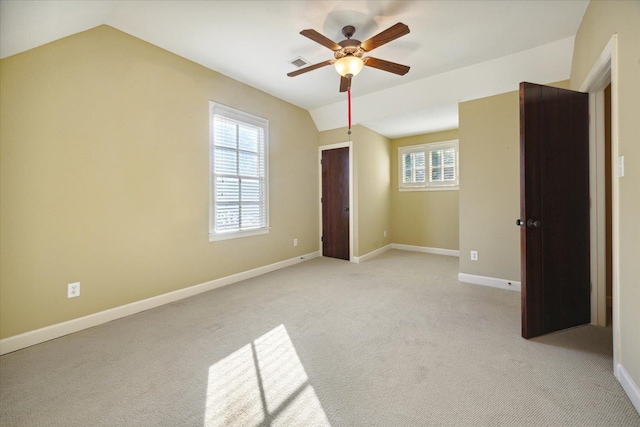 unfurnished bedroom featuring multiple windows, ceiling fan, and light carpet