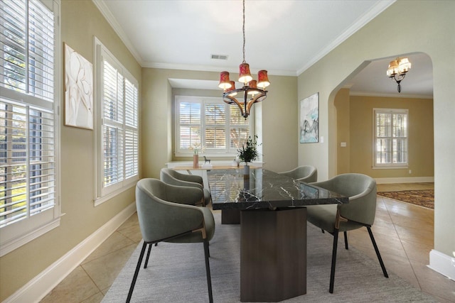 tiled dining room with a healthy amount of sunlight, crown molding, and a notable chandelier