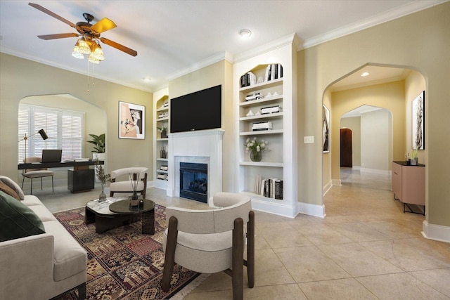 tiled living room featuring built in features, ceiling fan, and crown molding