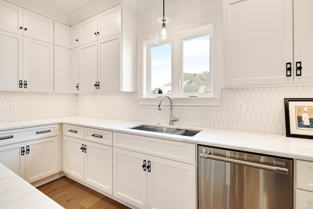 kitchen with hardwood / wood-style floors, dishwasher, white cabinetry, and sink