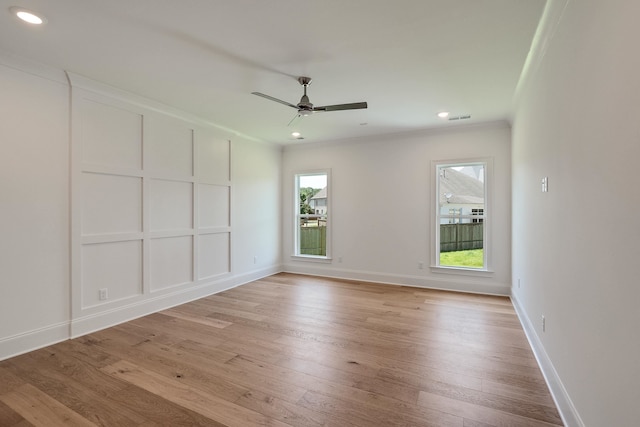 spare room with light wood-type flooring, plenty of natural light, ornamental molding, and ceiling fan