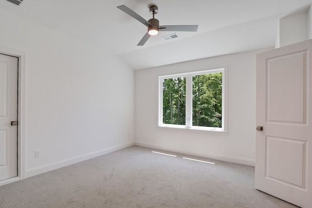 carpeted empty room featuring vaulted ceiling and ceiling fan