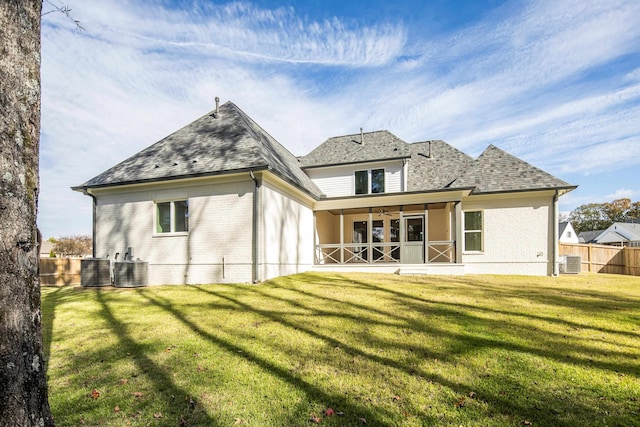 back of property featuring ceiling fan, a yard, and central AC unit