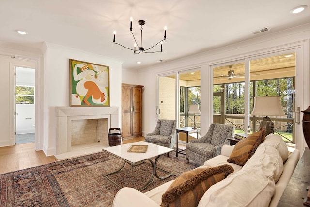 living room with plenty of natural light, crown molding, and light hardwood / wood-style flooring