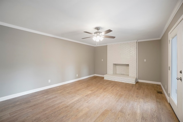 unfurnished living room with crown molding, light hardwood / wood-style flooring, ceiling fan, and a brick fireplace