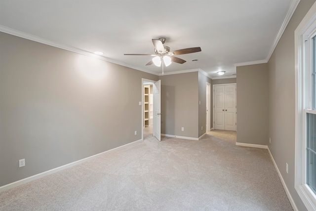 empty room with light colored carpet, ceiling fan, and ornamental molding