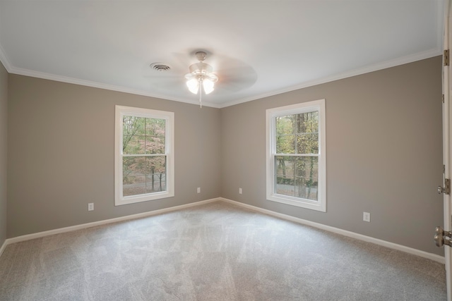 spare room featuring a healthy amount of sunlight, ornamental molding, and light carpet