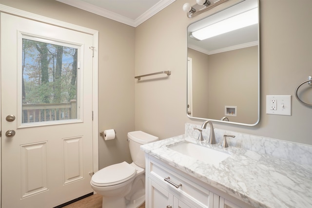 bathroom featuring toilet, vanity, and ornamental molding