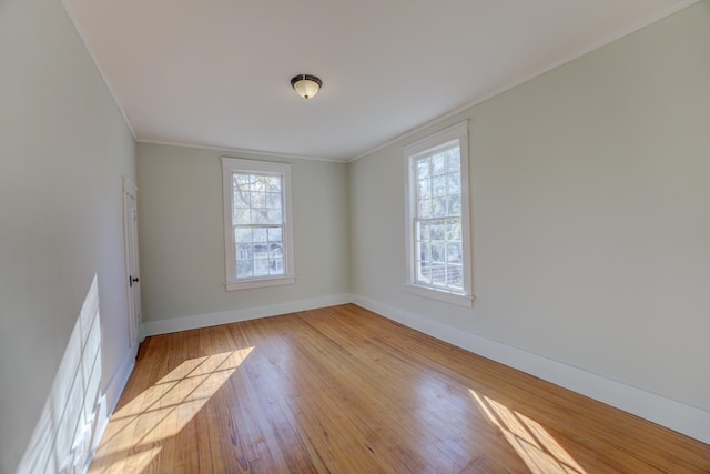 empty room featuring light hardwood / wood-style floors and crown molding