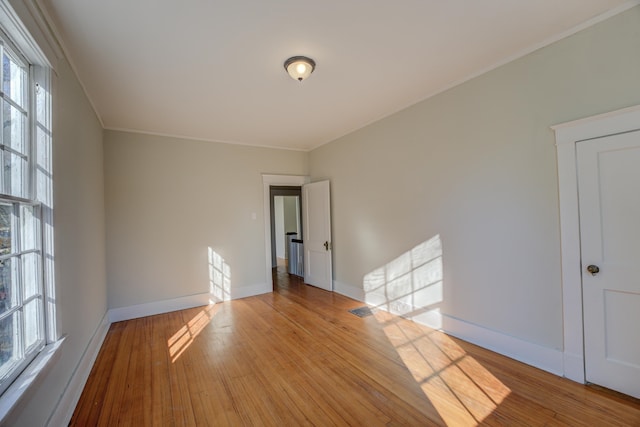 unfurnished room featuring light hardwood / wood-style floors and ornamental molding