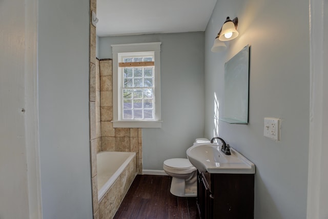 bathroom featuring hardwood / wood-style floors, a bathtub, toilet, and vanity