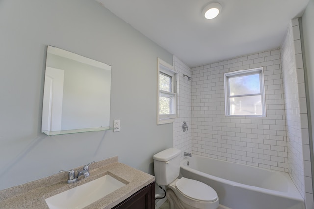 full bathroom featuring plenty of natural light, vanity, tiled shower / bath combo, and toilet