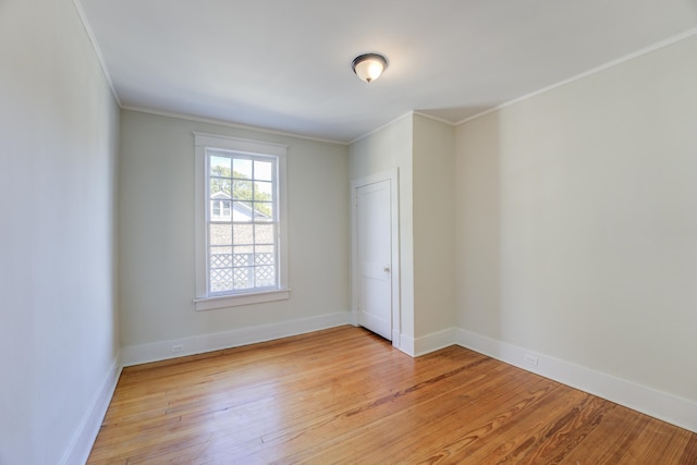 empty room with light hardwood / wood-style flooring and ornamental molding