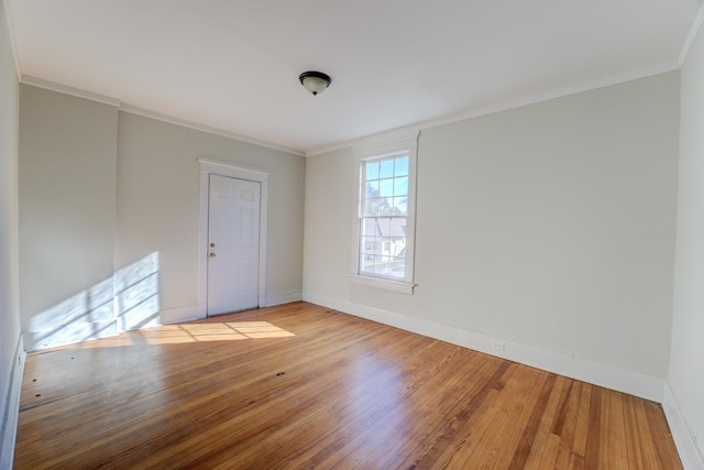 spare room featuring light hardwood / wood-style floors and ornamental molding