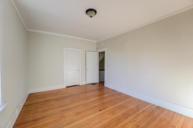 unfurnished room with light wood-type flooring and ornamental molding