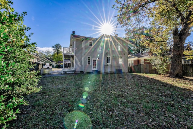 rear view of house featuring a yard and central AC unit