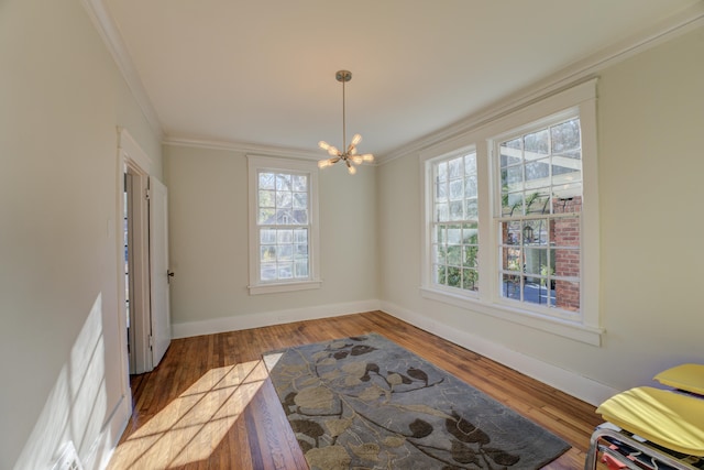 interior space featuring dark hardwood / wood-style floors, ornamental molding, and a chandelier