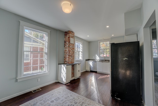 kitchen featuring black fridge, plenty of natural light, white cabinets, and dark hardwood / wood-style floors