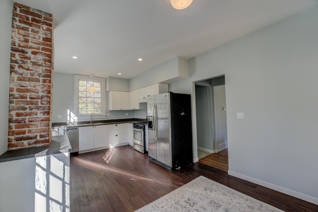 kitchen with sink, dark hardwood / wood-style flooring, white cabinets, and appliances with stainless steel finishes